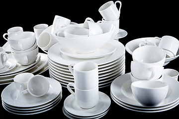 Image showing mixed white dishes cups and plates isolated on black