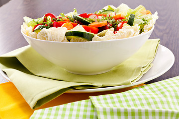 Image showing fresh mixed colorful salad on wooden table 