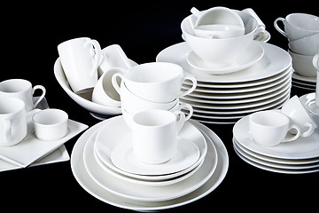 Image showing mixed white dishes cups and plates isolated on black