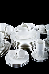 Image showing mixed white dishes cups and plates isolated on black