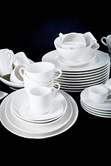 Image showing mixed white dishes cups and plates isolated on black