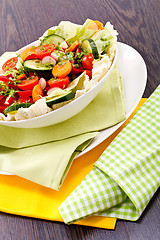 Image showing fresh mixed colorful salad on wooden table 