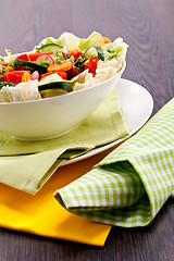 Image showing fresh mixed colorful salad on wooden table 