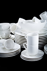 Image showing mixed white dishes cups and plates isolated on black