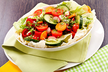 Image showing fresh mixed colorful salad on wooden table 