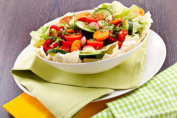 Image showing fresh mixed colorful salad on wooden table 