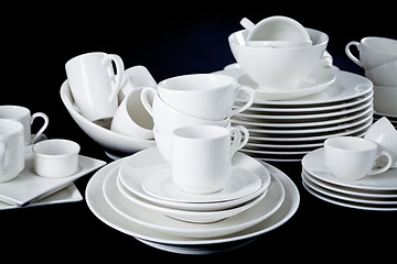 Image showing mixed white dishes cups and plates isolated on black
