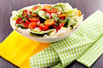 Image showing fresh mixed colorful salad on wooden table 