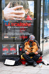Image showing PARIS - May 7: A homeless man sitting on the street with a dog a