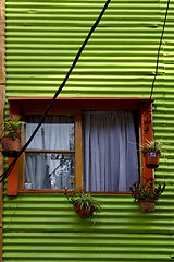 Image showing orange wood window and a green metal 