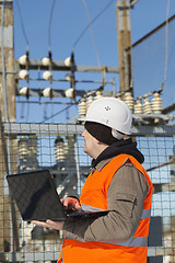 Image showing Electrician with computer near the electricity substation