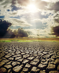 Image showing dry lake and dramatic sky with sun