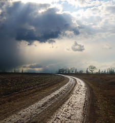 Image showing dramatic sky over field with dirty road