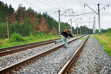 Image showing Elderly man crosses a railway embankment