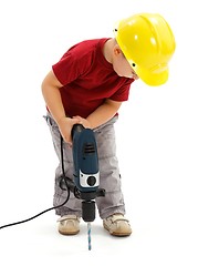 Image showing Little boy drilling in ground, wearing protective helmet