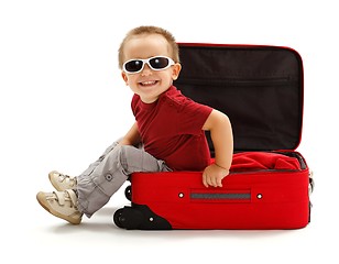 Image showing Playful little boy with sunglasses, sitting in suitcase