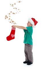 Image showing Joyful child releasing stars from Christmas stocking