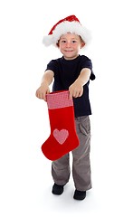 Image showing Smiling boy holding christmas stocking in front of him