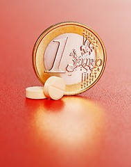 Image showing Two pills in front of one euro coin