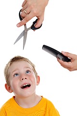 Image showing Scared little boy looking up to scissor and comb