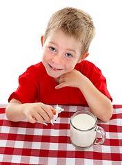 Image showing Young kid playing with toy cow near glass of milk