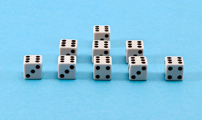 Image showing white gamble dice pyramid blue background 