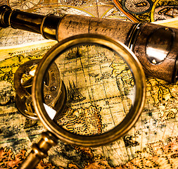Image showing Vintage magnifying glass lies on an ancient world map