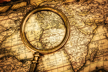 Image showing Vintage magnifying glass lies on an ancient world map