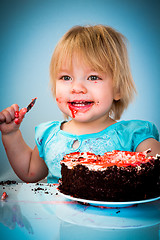 Image showing Little baby girl eating cake