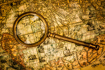 Image showing Vintage magnifying glass lies on an ancient world map