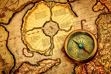 Image showing Vintage compass lies on an ancient map of the North Pole.