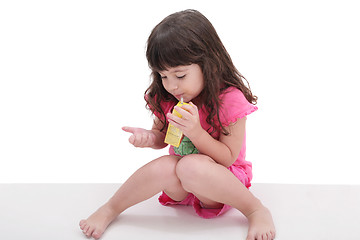 Image showing Close-up of beautiful little girl drinking from a juice box. Sho