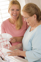 Image showing Senior Adult Woman and Young Daughter Talking in Kitchen