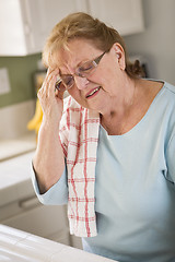 Image showing Senior Adult Woman At Kitchen Sink With Head Ache