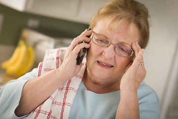 Image showing Shocked Senior Adult Woman on Cell Phone in Kitchen