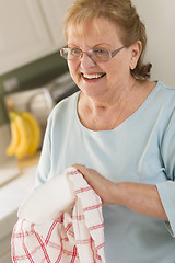 Image showing Senior Adult Woman Drying Bowl At Sink in Kitchen