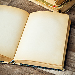 Image showing open old book on a wooden surface 