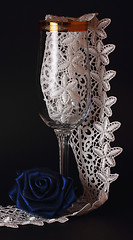 Image showing Blue silk rose and glass