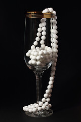 Image showing Glass and white necklace on a black 