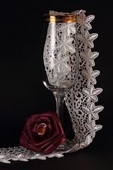Image showing Red silk rose and glass