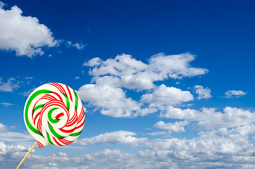 Image showing Single sugar lollipop in white green and red on background of sk