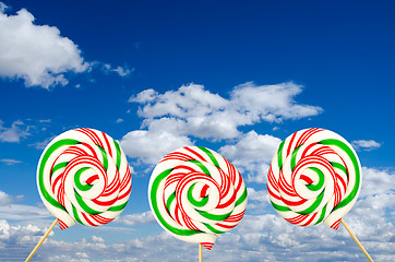 Image showing Three sugar lollipops in white green and red on background of sk