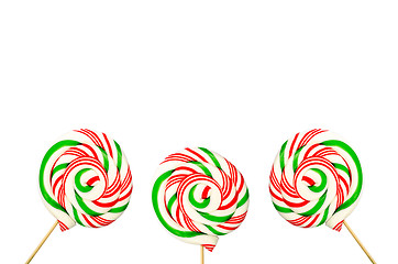 Image showing Three sugar lollipops in white green and red isolated on white b