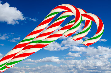 Image showing Three sugar sticks in white green and red on background sky and 