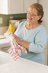 Image showing Senior Adult Woman Drying Bowl At Sink in Kitchen