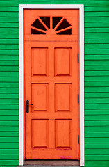 Image showing Red vintage wooden door and green wall