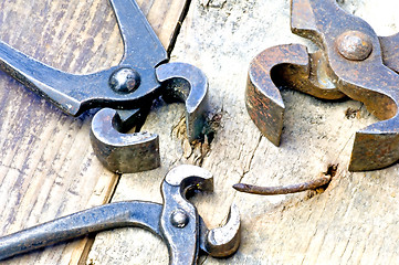 Image showing old rusty pliers with nail