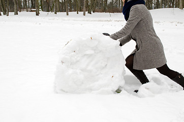 Image showing woman grey coat push big snow roll winter meadow 