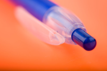 Image showing photo of a blue pen on orange notebook