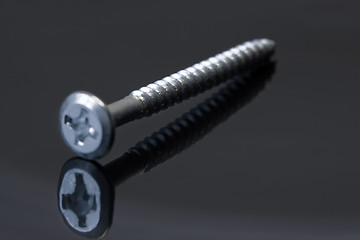 Image showing Steel screw on dark background